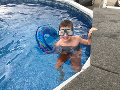Small boy in swimming pool in backyard in Erie, PA.