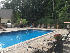 Fully landscaped in ground pool with loungers for guests.
